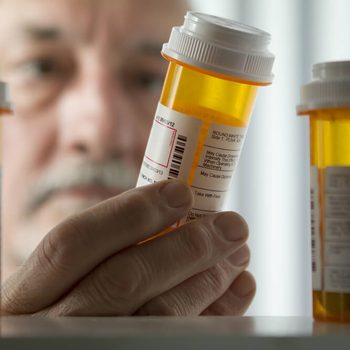 Man reading prescription bottle