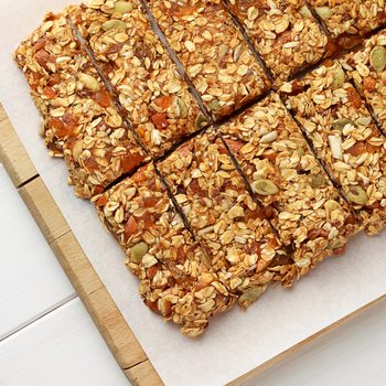 No baking granola bars on white wooden table. Healthy food for diet.