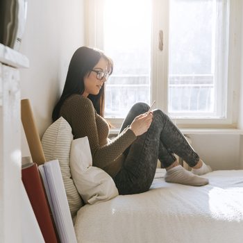 A Young Girl Using A Smartphone In The Bedroom