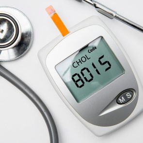 Closeup of medical device for measuring cholesterol with stethoscope on the table, isolated on white background