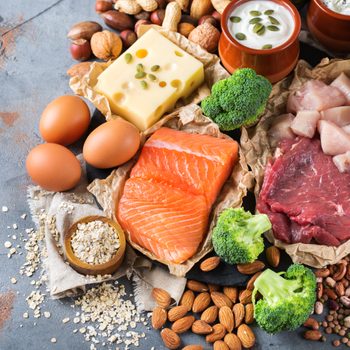 Assortment of healthy protein source and body building food. Meat beef salmon chicken breast eggs dairy products cheese yogurt beans artichokes broccoli nuts oat meal. Top view flat lay