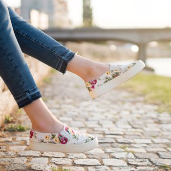 woman sitting on a wall wearing Floral slip on sneaker