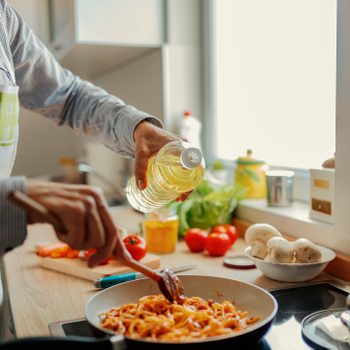 Woman adding olive from bottle