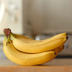 Bananas lie on a table in a kitchen