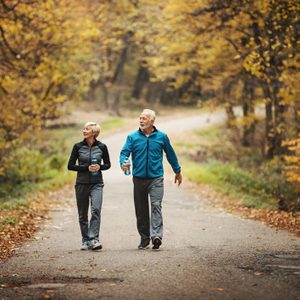 Senior couple power walking in a park.